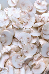 Sliced champignon mushrooms close up. Healthy food ingredient concept. Cooking background. Selective focus