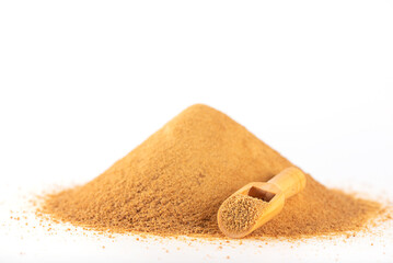 A pile with a wooden scoop with unrefined cane sugar Panela isolated on a white.