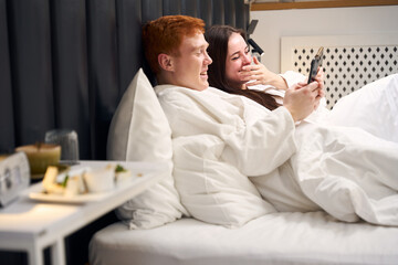 Cheerful couple is resting in a hotel room