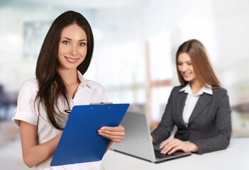 Fototapeta premium Young business woman with clipboard in office at work