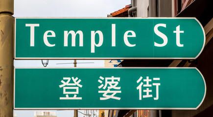 Naklejka premium Street sign in English and Chinese in downtown Singapore