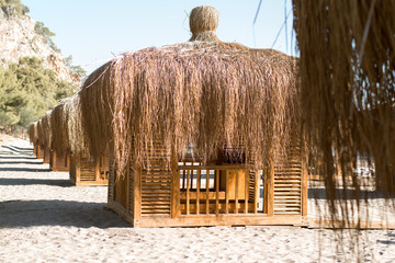 Wooden beach pavilions on the shore with mountains - the Mediterranean coast