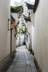 Fototapeta na wymiar Picturesque cobblestone alleyway lined with old white buildings