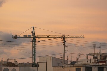Fototapeta na wymiar Stunning cityscape view of a town at sunset, with a network of power lines and cables