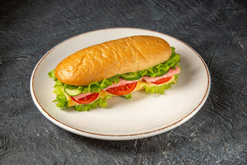 Vertical view of delicious homemade sandwich on a white plate on black distressed background