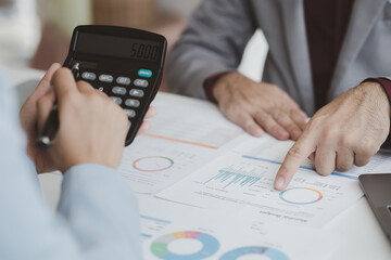 Two businessmen are brainstorming together and reviewing the company financial documents that the finance department has summarized, they are business partners. Business administration concept.