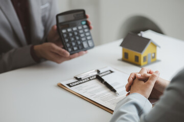 Real estate agents explain models of housing estates in projects to elaborate to clients, explaining and presenting information about homes and purchasing loans. Real estate trading concept.