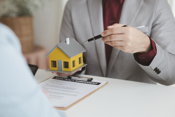 Real estate agents explain models of housing estates in projects to elaborate to clients,...