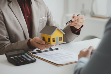 Real estate agents explain models of housing estates in projects to elaborate to clients,...