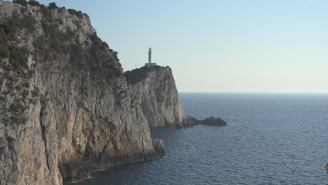 Lefkada Ducato lighthouse on the tall rocky seashore cliff, zoom out