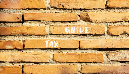 Tax guide symbol. Concept words Tax guide on beautiful red brown brick wall. Beautiful red brown brick wall background. Business and Tax guide concept. Copy space.