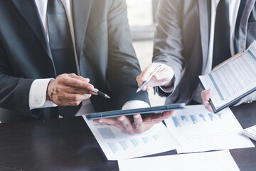Finance and investment concept, Businessman present business finance investment plan with his partner, Investor colleagues discussing new investment plan by financial graph data on office table