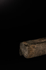 Trozo de madera antigua en fondo negro  ideal para exhibir productos cosméticos, alimenticios y otros / Piece of old wood on a black background ideal for displaying cosmetic, food and other products.