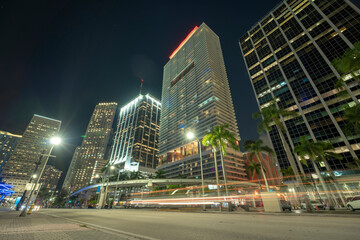 Fototapeta na wymiar Night urban landscape of downtown district of Miami Brickell in Florida USA. Illuminated high skyscraper buildings and street with car trails and Metrorail traffic in modern american megapolis