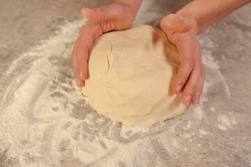 Person kneading a ball of dough, preparing to bake a delicious treat