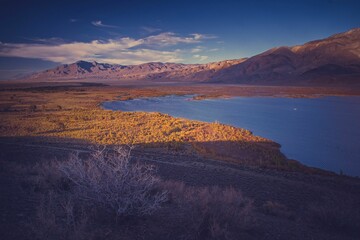 Beautiful view of the sun shining on the mountain range and a lake water