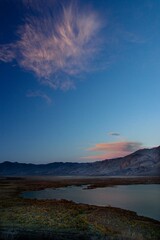 Naklejka premium Picturesque view of the sky at sunset, featuring fluffy white clouds and clear lake water