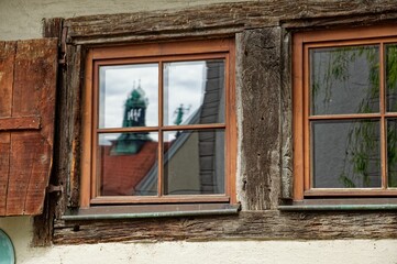 Old wooden window reflecting a German city view