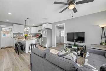 Studio apartment with light-colored walls separating a modern living room and kitchen