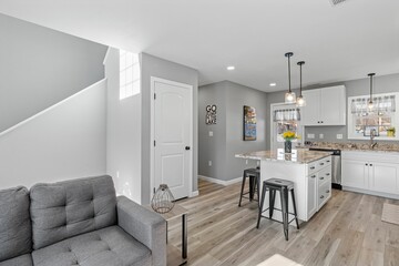 Studio apartment with light-colored walls separating a modern living room and kitchen