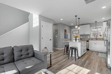 Studio apartment with light-colored walls separating a modern living room and kitchen