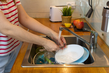 person washing dishes in kitchen