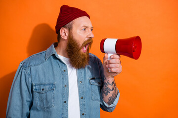 Photo of hipster man red hair beard scream loud megaphone empty space announce new shopping season black friday isolated on orange color background