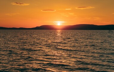 Tranquil lake illuminated by a vibrant sunset in summer