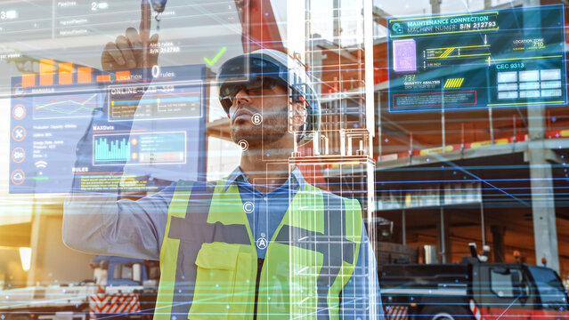 Futuristic Architectural Engineer Wearing Augmented Reality Headset, Uses Gestures to Create 3D Graphics VFX Model of a Building with Infographics. In Background Construction in Progress