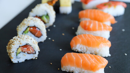 close up of sushi set on dark tray