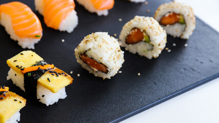 close up of sushi set on dark tray