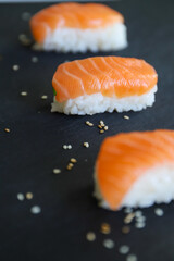 close up of nigiri sushis on dark tray
