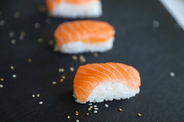 close up of nigiri sushis on dark tray