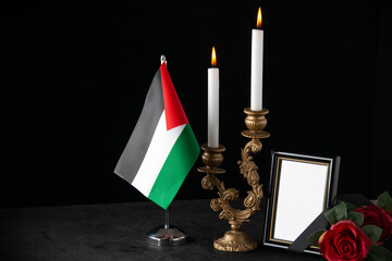 front view of burning candles with picture frame as memory on dark background funeral death