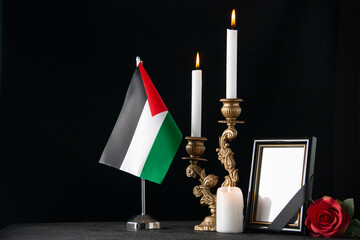 front view of burning candles with picture frame on dark floor palestine funeral death