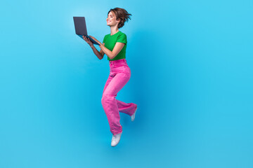 Full length photo of shiny adorable woman dressed green top jumping high texting modern gadget...