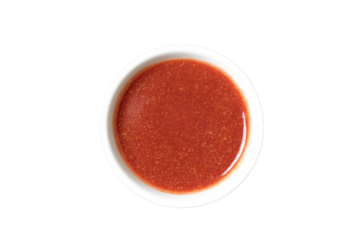 Sweet and sour sauce in a bowl isolated on white background. Red hot sauce from chilli peppers and tomatoes.