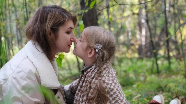 Hello September. A young mother and little daughter walk in the city park in autumn.