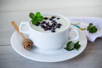 Fototapeta na wymiar Cooked milk semolina porridge with berries and honey in a plate.