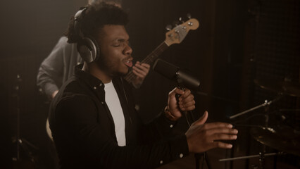 African American vocalist sings lyrical composition into microphone in soundproof room. Cool...