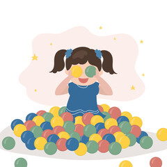 Funny little girl sits and plays in the pool with plastic balls. Children's party in the entertaining playroom. Colored play balls for small children