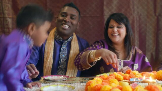 MS Parents and sons (2-3, 6-7) eating sweets on Diwali