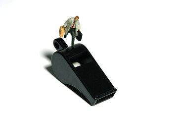 Miniature people toy figure photography. Whistle blower concept illustration. A businessman running...