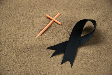 front view of stick cross with black bow on the sand death israel war funeral palestine
