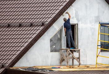 Workers are priming outside the walls of the house.