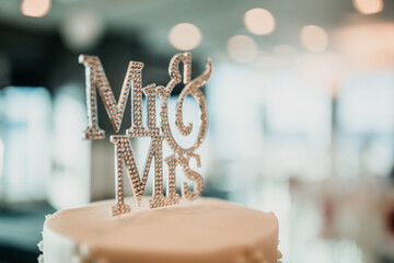 Mr & Mrs cake topper sign on a wedding cake at the reception.