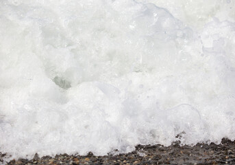 White sea water wave on the shore as a background