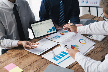 Close up view of business partners discussing documents and ideas at meeting room while using digital tablet to present their idea.