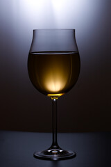 Glass of white wine on black background
