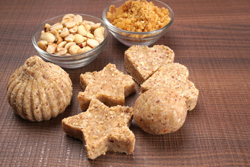 Homemade healthy and sweet groundnut or peanut and Jaggery Laddoo, delicious indian sweet served on a wooden background.Roasted peanut isolated.